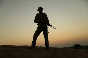 The silhouette of a modern soldier on sunset.